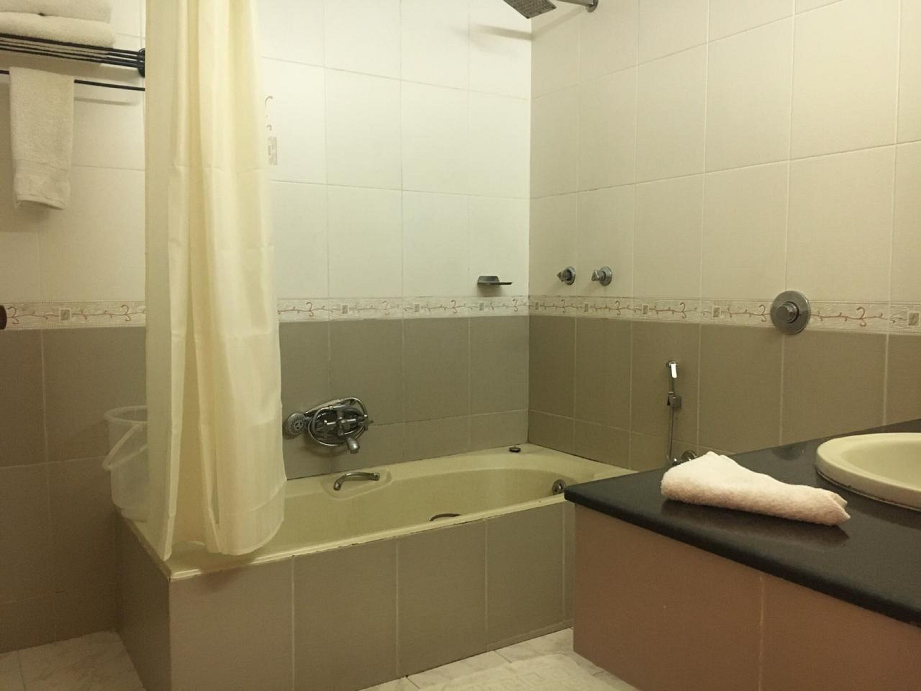 A bathroom with a bathtub, a sink, and a shower curtain.
