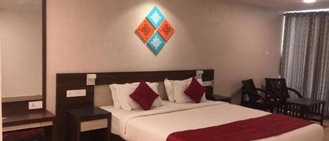 Una habitación de hotel con una cama grande, un escritorio y una silla.