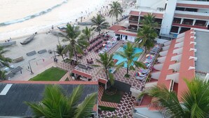 A hotel with a pool area, outdoor seating, and a beach view. - Hotel Sea Face (Neyyattinkara)