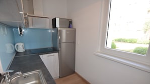 A compact kitchen with a stainless steel refrigerator, a microwave, and a kettle. - Victus Apartamenty - Marina (Sopot)
