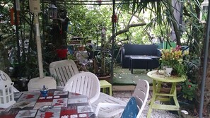 An outdoor patio with a table, chairs, and potted plants. - Domaine des Plantes (Rennes)