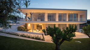 A modern two-story house with large glass windows, a flat roof, and a well-maintained garden. - Capo Torre Resort (Albisola Superiore)