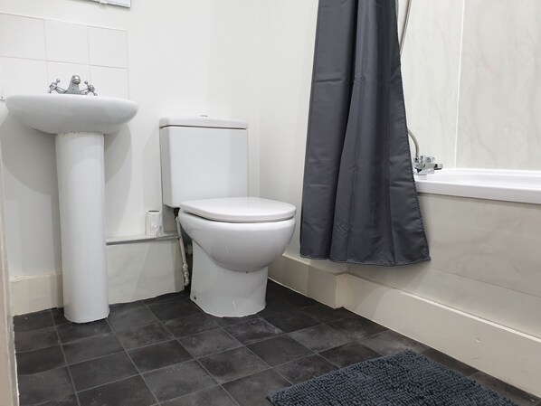 A bathroom with a white sink, toilet, and bathtub.