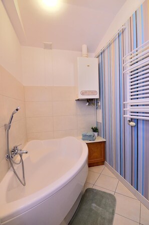 Bathtub, hair dryer, towels, shampoo