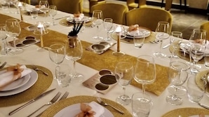A long dining table set with multiple place settings, including plates, cutlery, and glasses. - Hotel Up Museum - Wellness & Spa (Foggia)