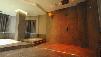 Un baño moderno con una bañera grande, zona de ducha y tocador con espejo.