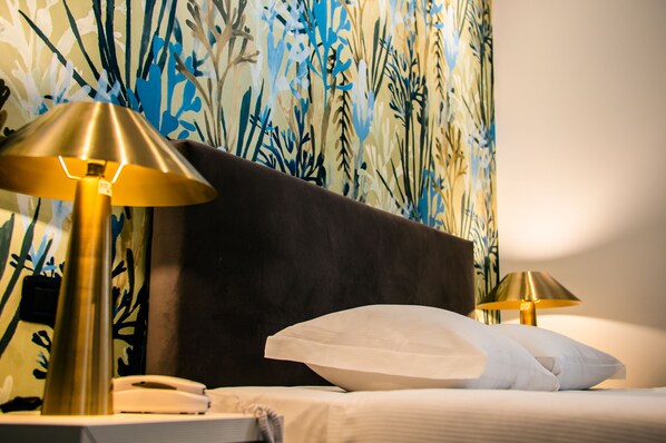 A hotel room with a bed, two bedside lamps, a telephone, and a floral wallpaper. - Hotel Up Museum - Wellness & Spa (Foggia)