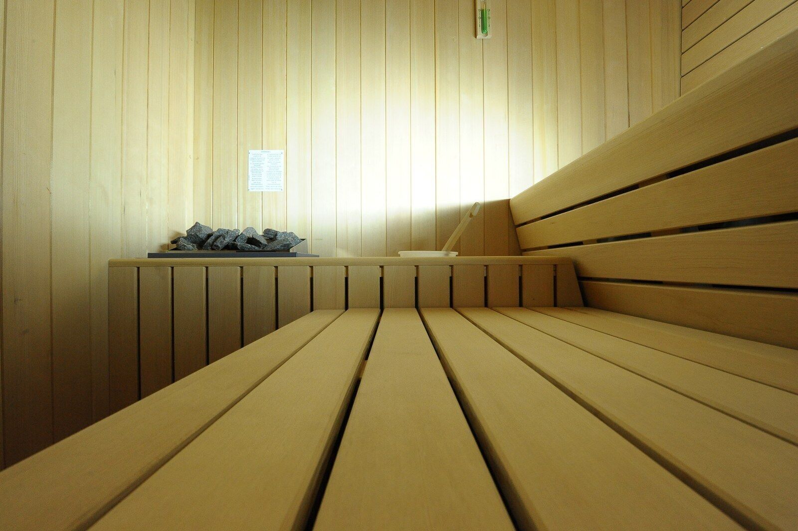 A sauna with wooden benches and a bench with a towel.
