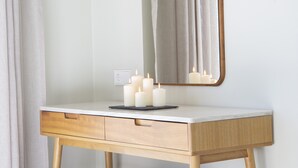 A bathroom vanity with a mirror, three lit candles, and a light switch on the wall. - Elegant stone-built Villa, with heated pool and amazing view (Lefkada)