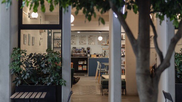 An indoor café with a counter, seating area, and a menu board. - NIU Modern & Centric Lofts (Mexico City)