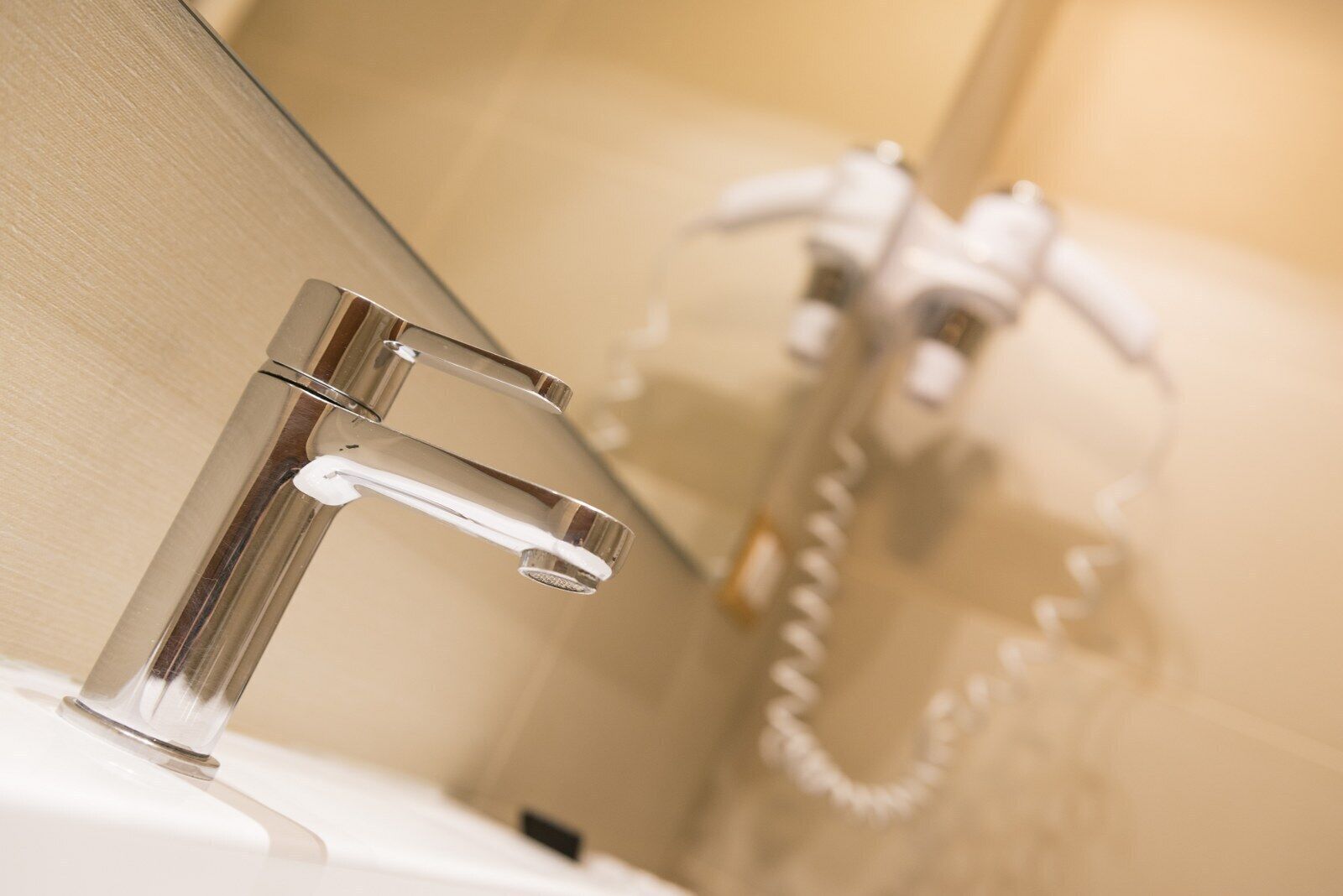 A modern bathroom with a chrome faucet and a shower head.