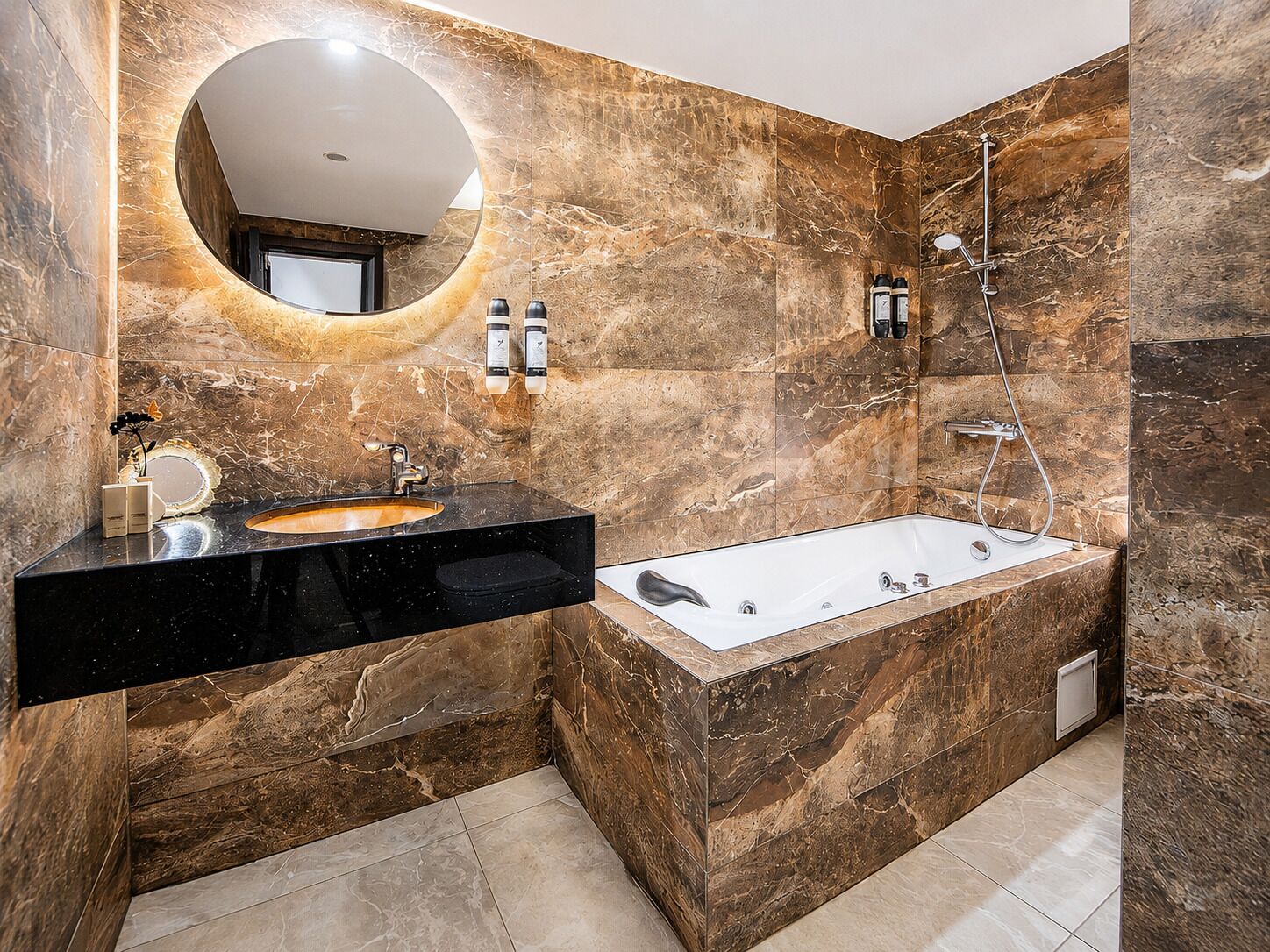 Un baño moderno con un lavamanos negro, un espejo grande y una ducha a ras de suelo.
