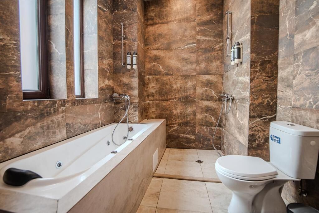 A bathroom with a bathtub, toilet, and shower.
