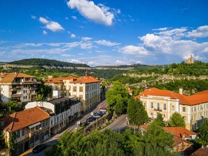 A town with historic buildings, a prominent church, and a castle on a hill. - Hotel Tsarevets (Veliko Tarnovo)