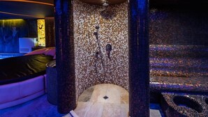 Een moderne badkamer met wandtegels van mozaïek, een badkuip en een douche.