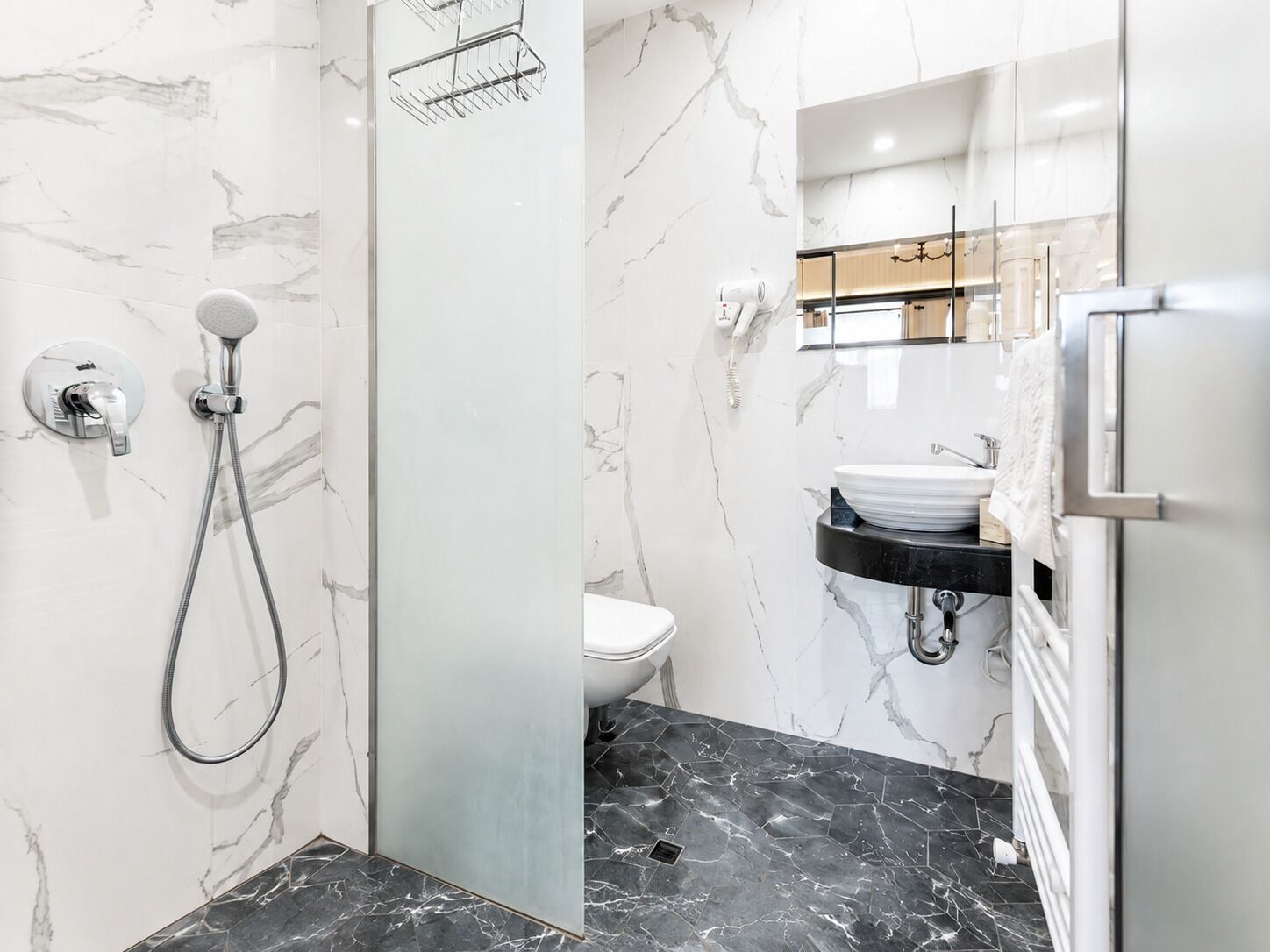 A bathroom with a shower, toilet, and sink.