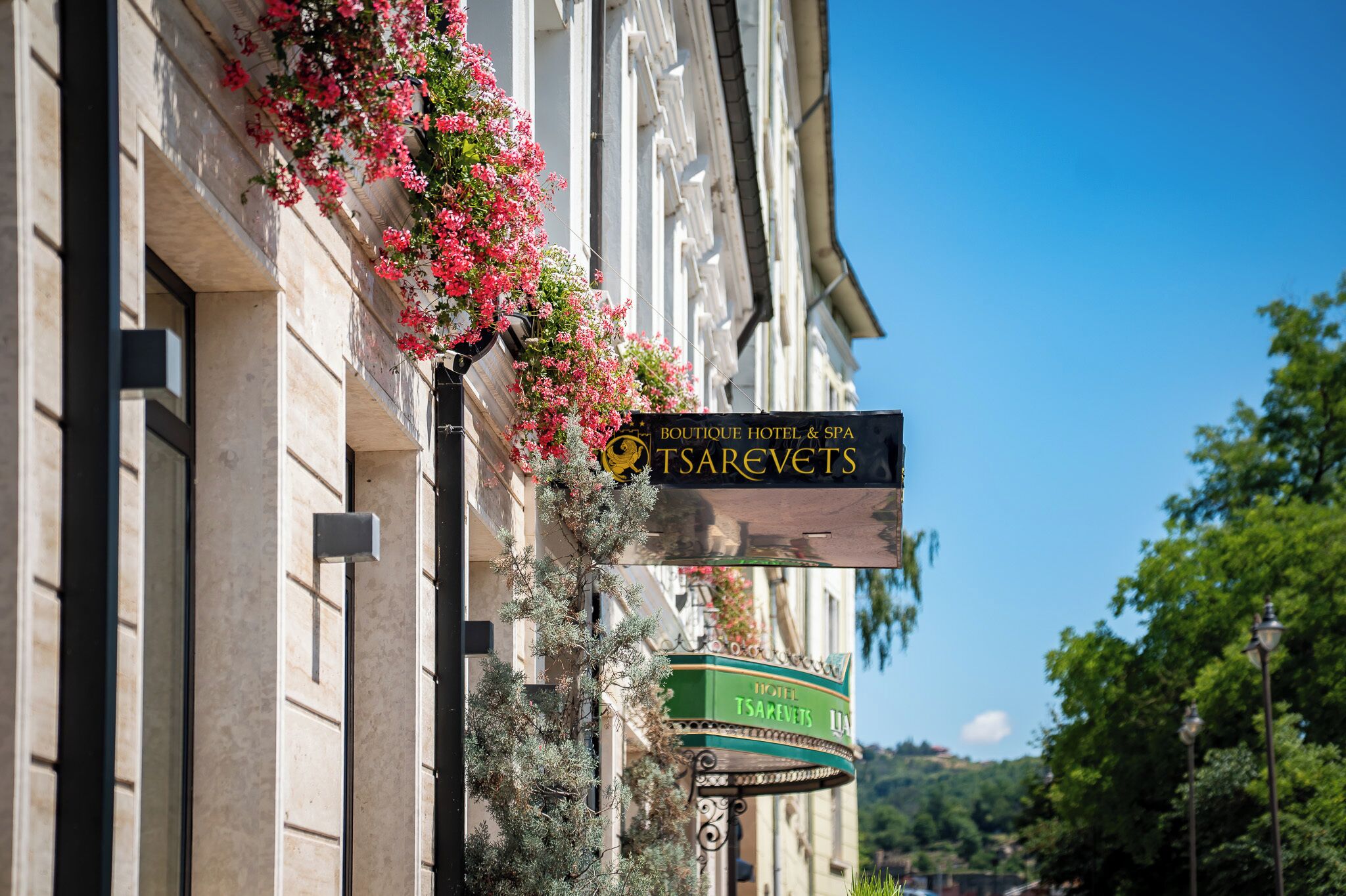 Ein Hotelschild mit dem Namen 'TSAREVETS' und einem darunterliegenden grünen Schild.