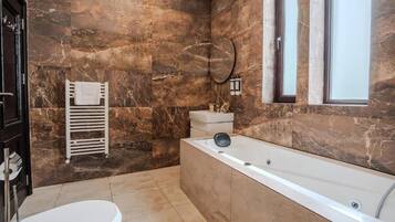 Un baño con bañera, inodoro y un perchero para toallas.