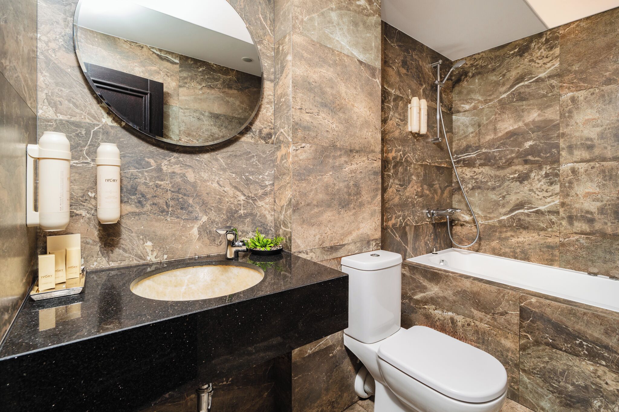 A bathroom with a marble sink, toilet, and shower.