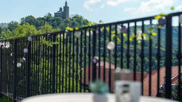 Un balcón con vistas a una iglesia y follaje verde.