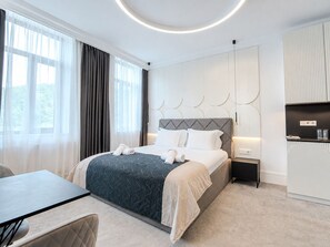 A modern hotel room with a bed, bedside table, and a view of the outdoors. - Hotel Tsarevets (Veliko Tarnovo)