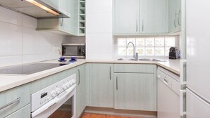 A kitchen with light green cabinets, white countertops, a Bosch oven, a microwave, and a dishwasher. - 1SARR 01 - Apartment for 4 people  located in Llafranc only 170m from the beach (Llafranc)