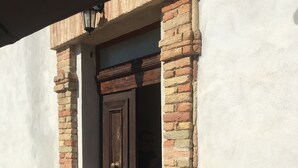 Een gebouwtravee met een houten deur en bakstenen zuilen.