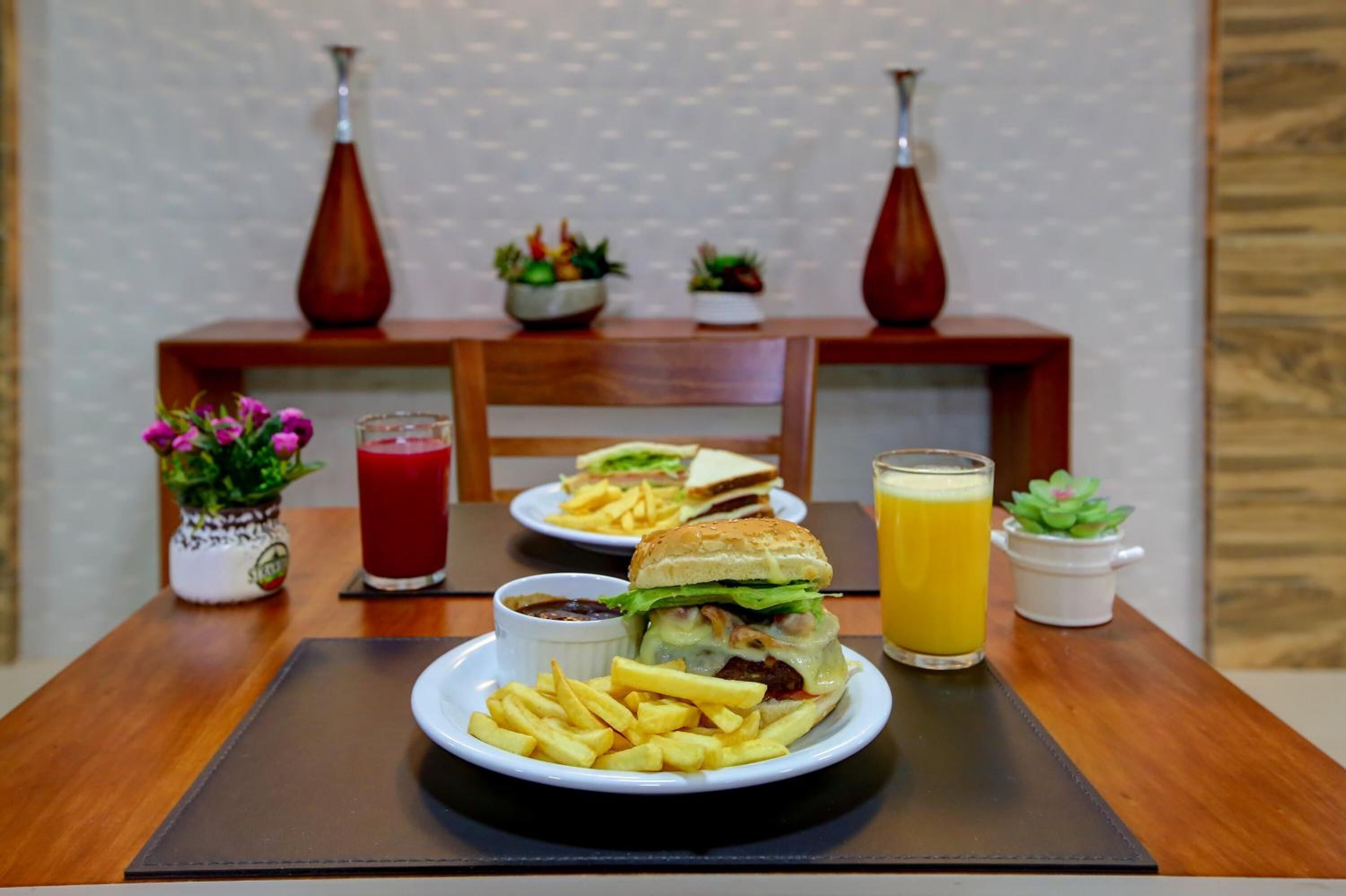 Uma mesa de jantar com um prato de comida, um copo de suco e uma bebida.