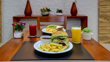 Uma mesa de jantar com um prato de comida, um copo de suco e uma bebida.