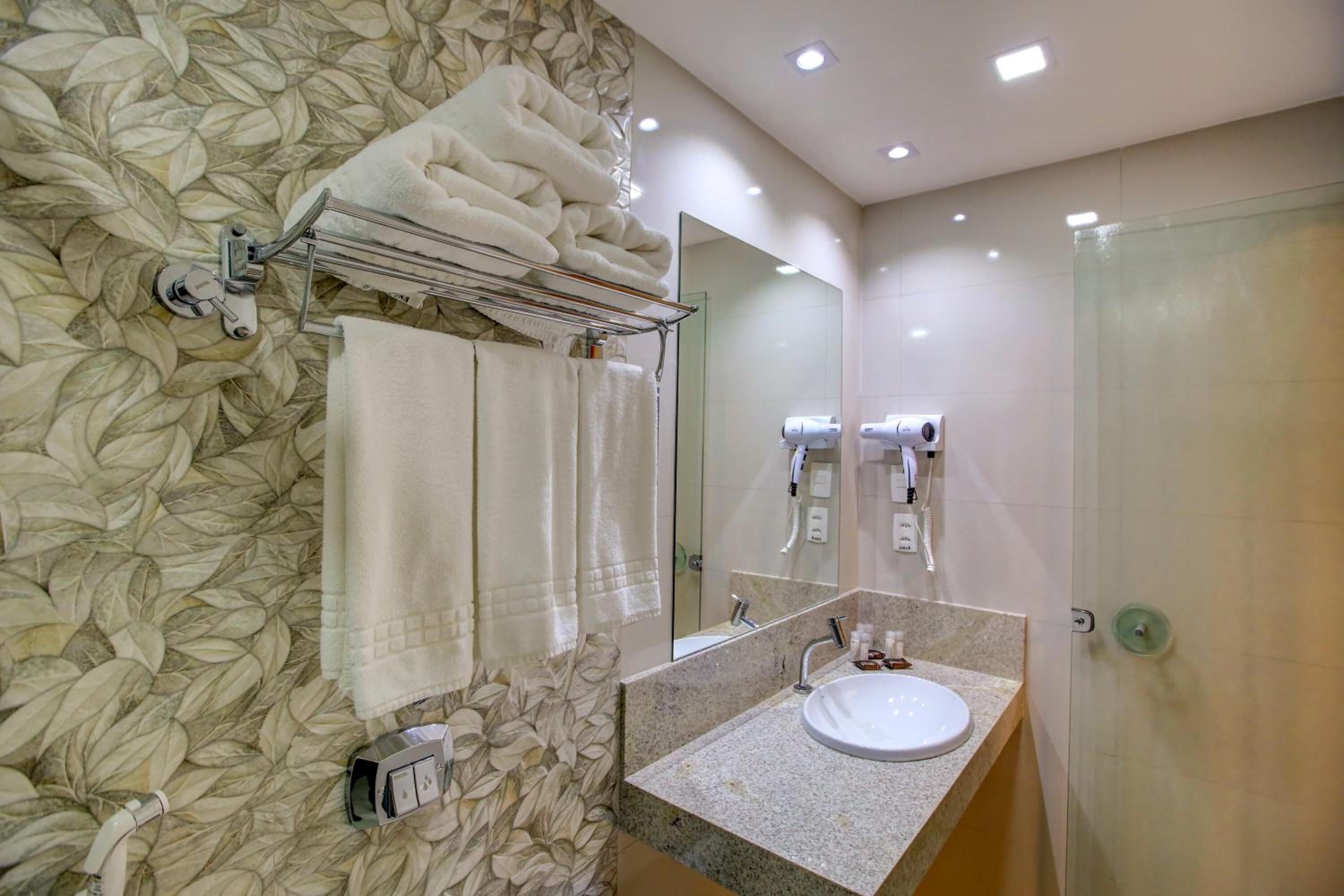 shower, hair dryer, towels, toilet paper