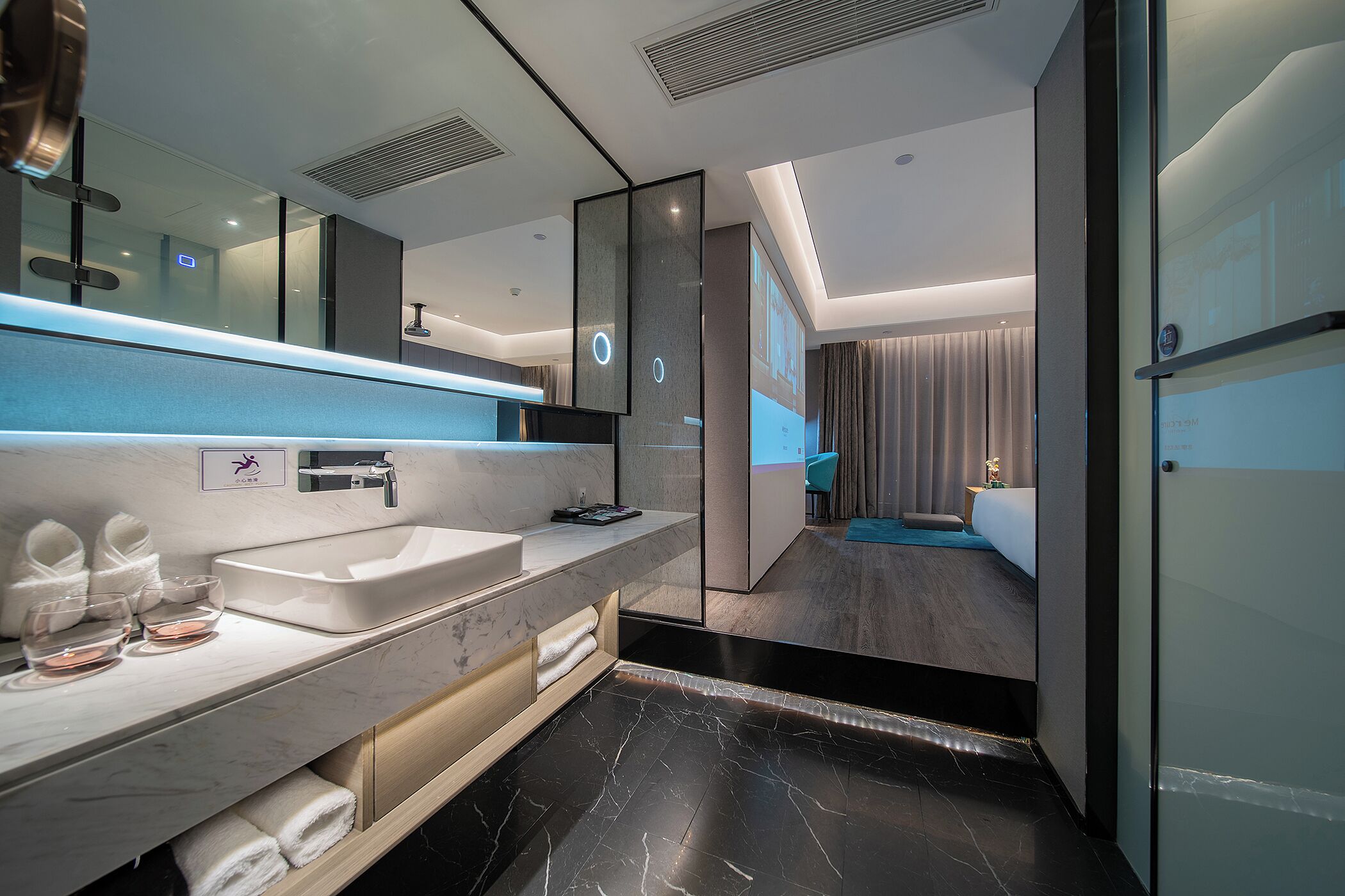 A modern bathroom with a large mirror, a sink, and a shower area.