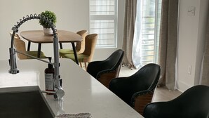 A kitchen with a white countertop, a sink, a bottle of hand soap, a jar of jam, and a potted plant. - 5 Queen Bed 4 Full Bath Luxury Home, 1.4 miles to Bank of America Stadium (Charlotte)