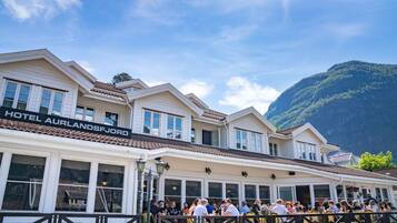 A hotel with a sign reading "HOTEL AURLANDSJORD" and a crowd of people outside.