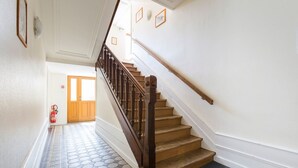 Eine Treppe mit hölzernen Geländern und einem gemusterten Boden, der zu einer Tür führt.