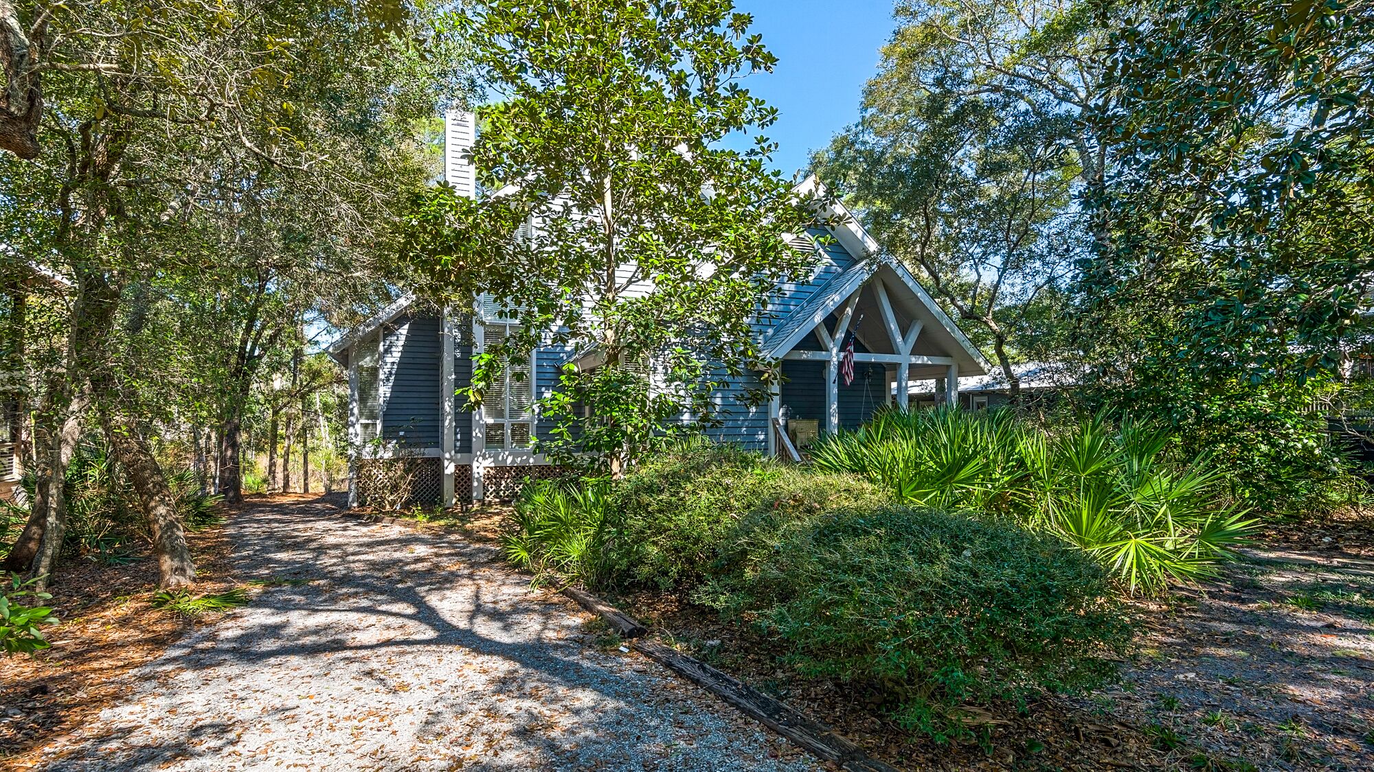 A pathway leading to a house surrounded by dense foliage and trees.