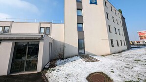 Un bâtiment moderne avec une enseigne indiquant la présence d’hôtels ibis budget.