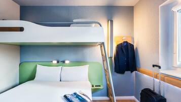 A bunk bed room with a magazine on the bed, a suitcase, and a jacket hanging on the wall.