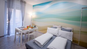 A bedroom with a bed, pillows, a bedside table with a lamp, and a wall mural.