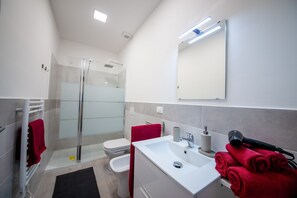 A modern bathroom with a glass shower enclosure, a white sink, and a mirror above it. - Ines - 2-4 people (Albenga)