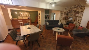 Ein Essbereich mit Tisch, Stühlen, einer Couch und einer Steinwand.