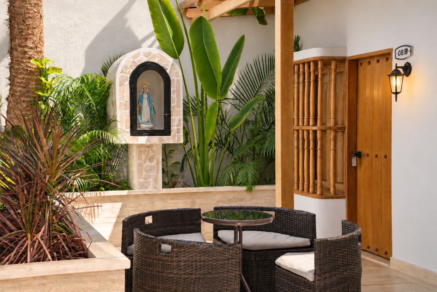 An outdoor seating area with wicker furniture, a statue, and a wooden door.