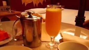 A breakfast setting with plates of food, a pitcher, a glass of orange juice, and a cup on a table. - Pousada e Motel Blue Inn (Cascavel)