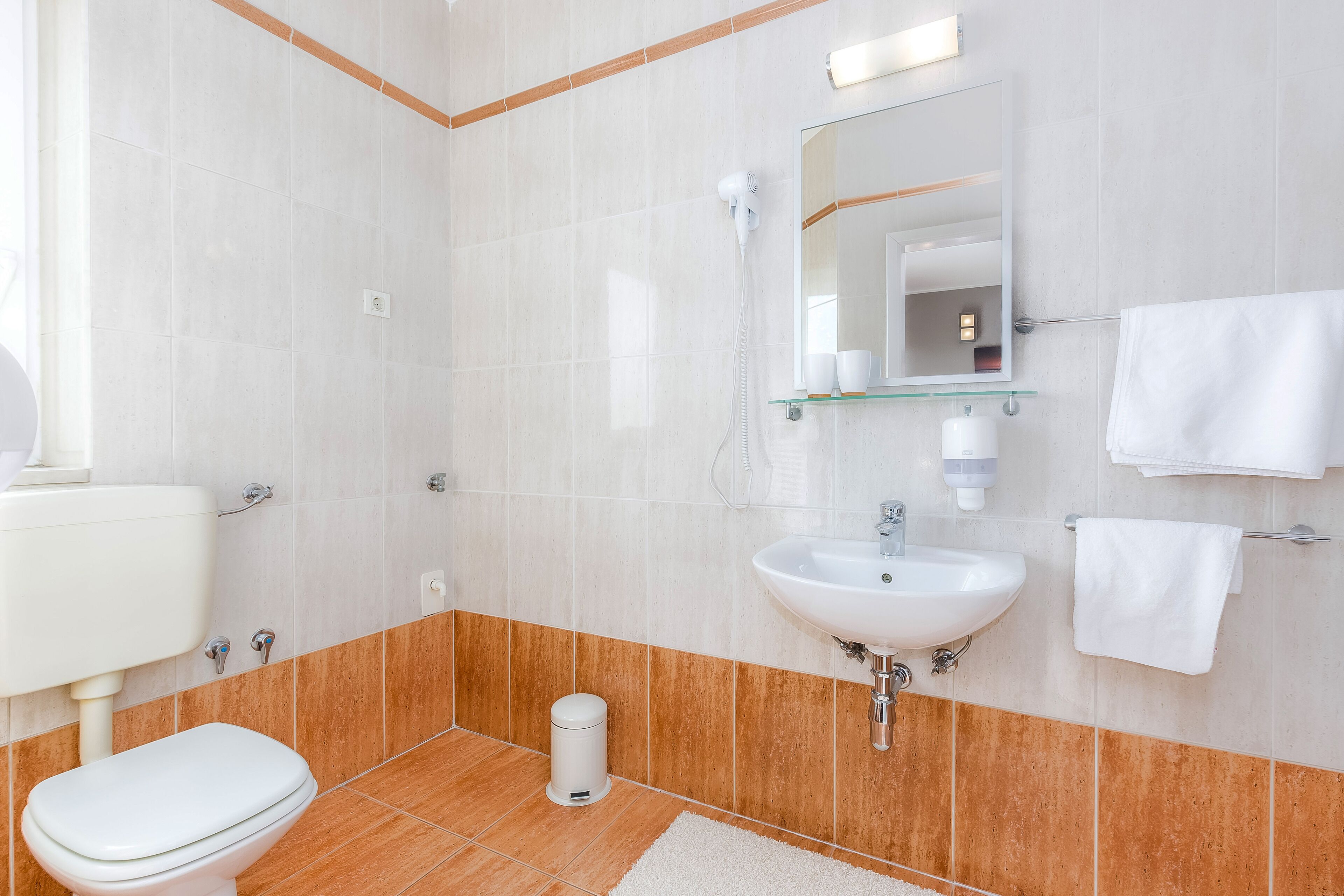 Een moderne badkamer met toilet, wastafel en douche.