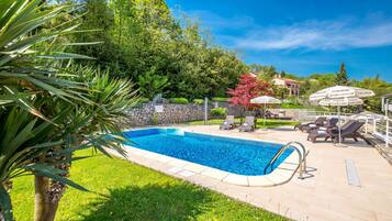 Alberca al aire libre por temporada y sombrillas en la alberca