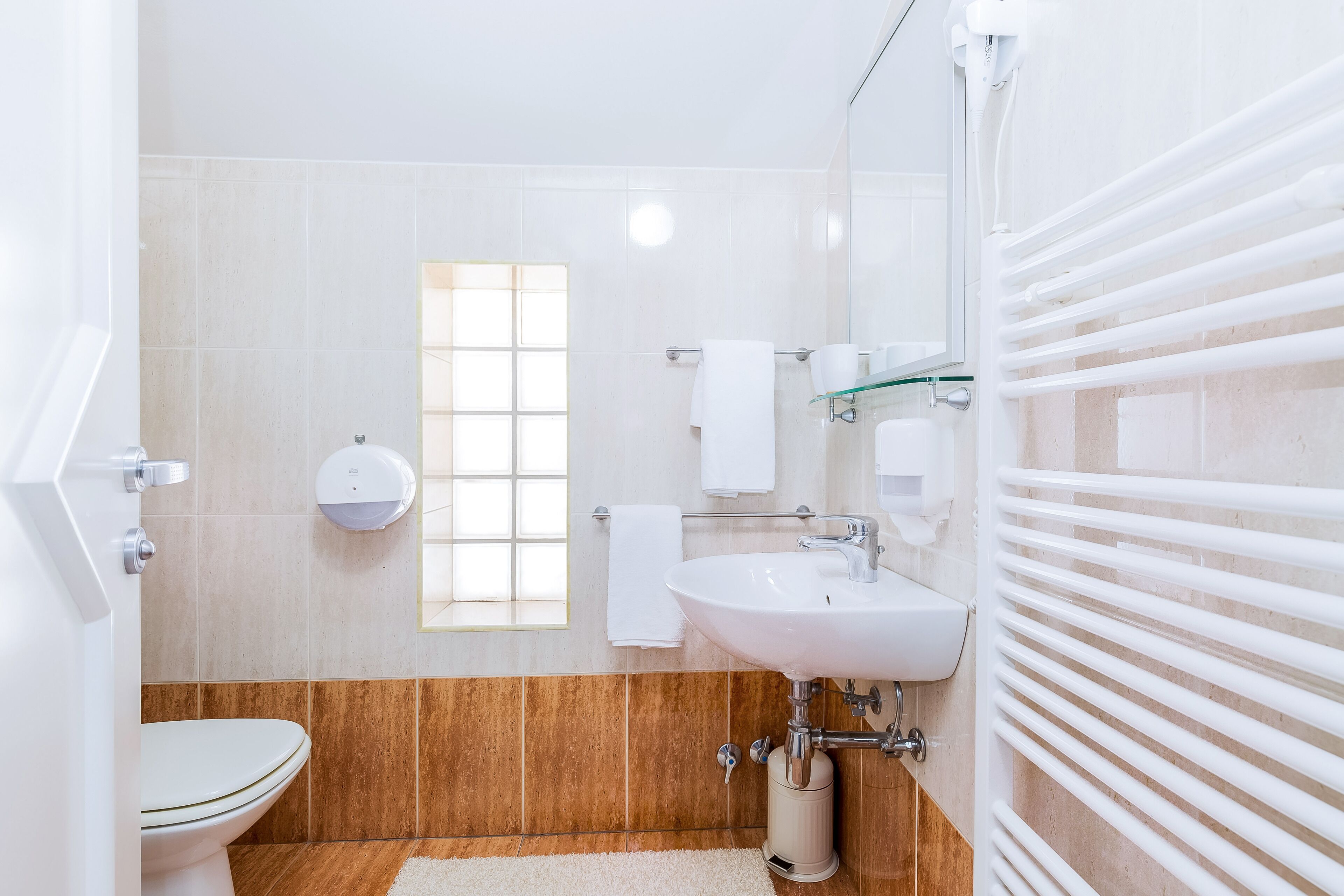 Ein modernes Badezimmer mit Toilette, Waschbecken und einer Duschkabine aus Glas.