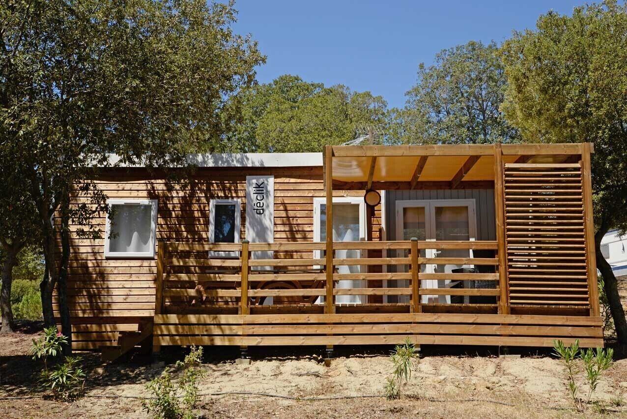 A wooden cabin with a covered porch, windows, and a sign that reads "BIECKIJK."