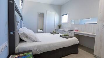 A modern bedroom with a bed, bedside table, and a window.