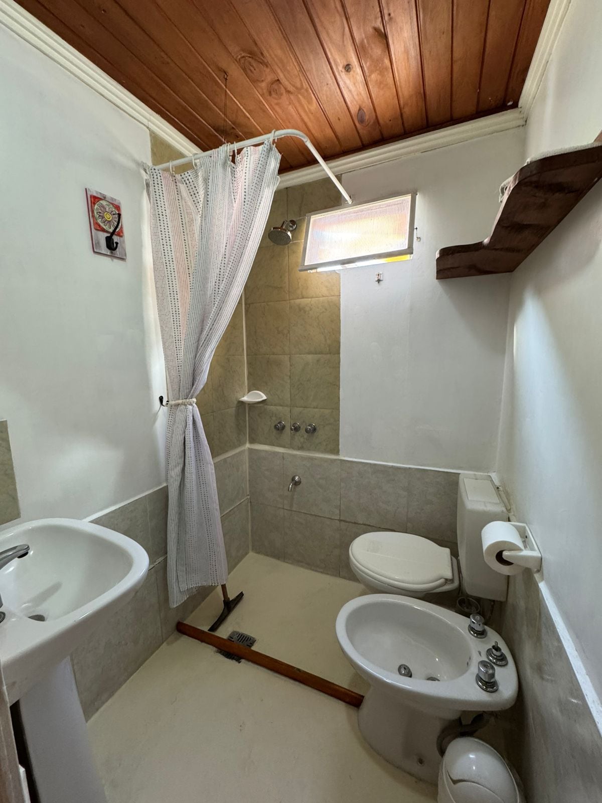 Une petite salle de bain avec une douche, des toilettes et un lavabo.