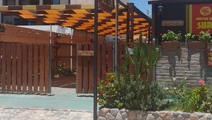 Un hostal con valla de madera y un cartel.