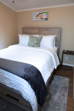 A neatly made bed with a headboard, a bedside table, and a painting on the wall. - (Fishing from dock) Boat Launch, Seafood Market & Bait-tackle shop next door.... (Eastpoint)